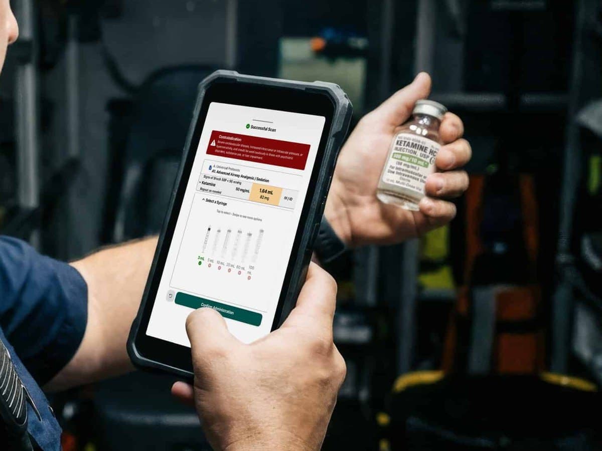 Paramedic scanning a medication vial with eMACC on a rugged phone